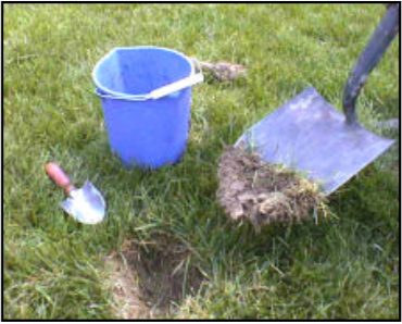 A shovel used to open a whole in grass ground