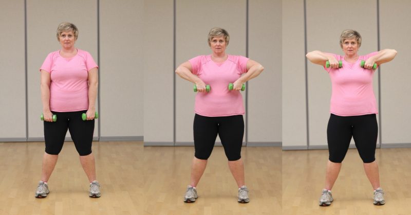 Three images showing a woman holding dumbells. on the first image, she is holding them and standing with feet hip-distance apart and her hands down by her side with palms facing her chest. On the second image she bended her elbows to bring her fists up to chest. On the third images she has her fists up to the chest level.